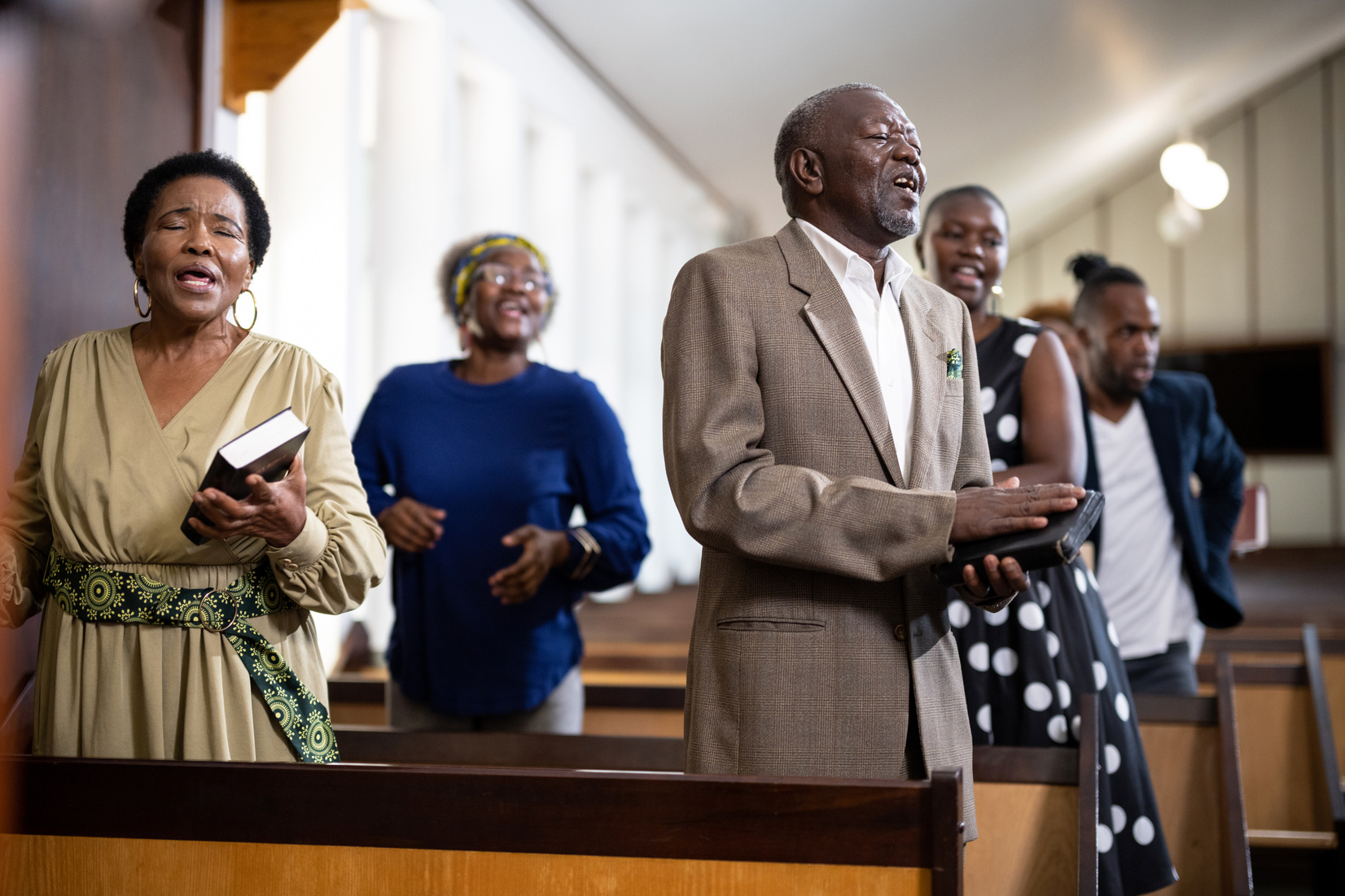 Senior member of congregation singing in church